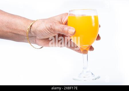 Hand hält ein Glas Orangen- oder Mangobaft isoliert auf weißem Hintergrund. Nahaufnahme Stockfoto