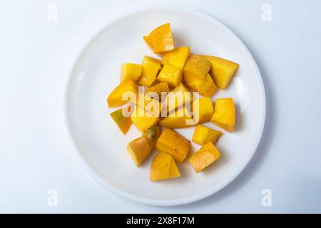 Reife köstliche Mangoblätter auf weißer Platte isoliert auf weißem Hintergrund. Nahaufnahme Stockfoto