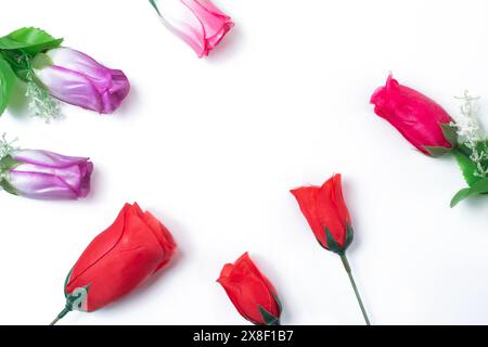 Blumenzusammensetzung. Mehrfarbige künstliche Rosen Blumen Tulpen auf weißem Hintergrund mit Kopierraum. Draufsicht. Stockfoto