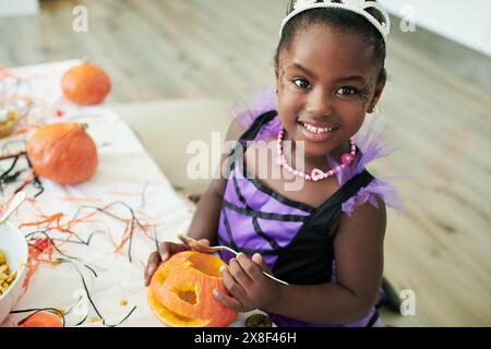 Porträt, Kind und Prinzessin Kostüm für halloween, Geburtstag oder Party bei einer Veranstaltung als Kinder zum Feiern. Mädchen, fröhlich und kreativ mit Kürbis für Stockfoto