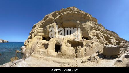 Panoramablick auf die ehemalige römische Nekropole mit Sandsteinhöhlen in Sandsteingräber Höhlengräber Grotten in Felsen auf der Nordseite der Matala Bay, in Stockfoto