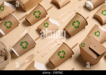 Set aus umweltfreundlichen Lebensmittelverpackungen mit Recycling-Symbolen auf beigefarbenem Hintergrund Stockfoto