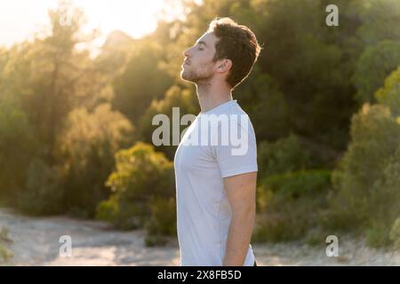 Attraktiver Mann, der draußen frische Luft atmet. Gesundheit und Wellness Stockfoto