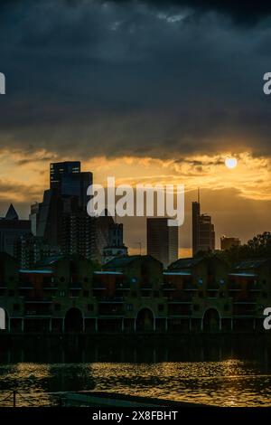 London, Großbritannien. Mai 2024. Die Sonne untergeht über dem Shadwell Basin, der City of London und dem Maynards Quay - das warme Sommerwetter bei Sonnenuntergang verleiht dem Blick auf die Stadt von den Docklands, London, eine dramatische Atmosphäre. Guy Bell/Alamy Live News Stockfoto