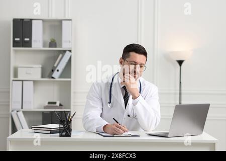 Arzt mit Online-Beratung per Laptop am Tisch in der Klinik Stockfoto