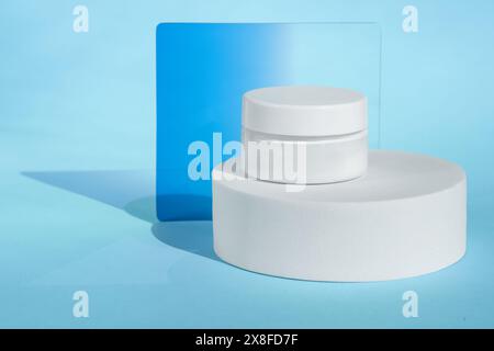 Weißes Kosmetikglas auf blauem Hintergrund Stockfoto