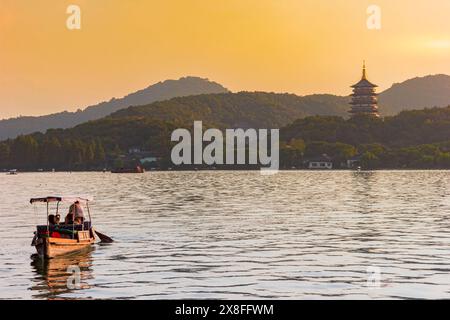 Holzboot bei Sonnenuntergang auf dem Westsee in Hangzhou, China Stockfoto