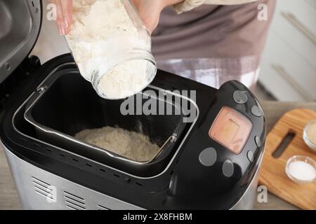 Teig herstellen. Frau, die Mehl in die Brotbackmaschine gibt, Nahaufnahme Stockfoto