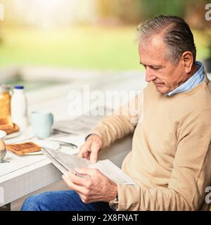 Reife, Geschäftsmann und Zeitung zum Lesen im Hinterhof mit Frühstück und Informationen. Börse, Artikel und ceo mit Wissen am Tisch in Stockfoto
