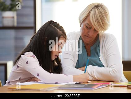 Lernen, Mädchen und Zeichnen im Haus mit Großmutter, um Kreativität, Kunst und Kindheitserinnerungen mit Liebe zu fördern. Oma, Kind und Hausaufgaben zu Hause Stockfoto