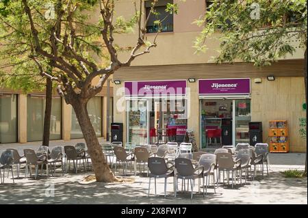 Viladecans, Barcelona, Spanien-25. Mai 2024: Urbane Szene mit einer Terrasse voller grauer Stühle und Tische vor dem Jijonenca-Geschäft, ein perfekter Ort für die Stadt Stockfoto