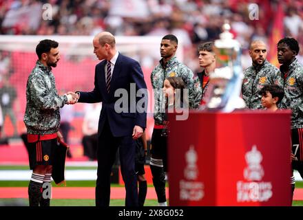Der Prince of Wales schüttelt sich vor dem Finale des Emirates FA Cup im Wembley Stadium, London, mit Bruno Fernandes von Manchester United (links) die Hand. Bilddatum: Samstag, 25. Mai 2024. Stockfoto