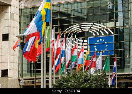 Sitz des Europäischen Parlaments. Architektur und Glasfassaden an einem Ort, an dem sich europäische und globale Kulturen treffen. Friedensflaggen schwenken Euro-Statue Stockfoto