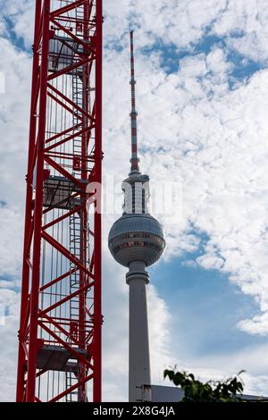 Ein hoher Turm mit einer roten Spitze steht vor einem blauen Himmel Stockfoto
