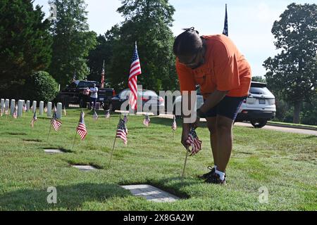 Raleigh, NC, USA, 25. Mai 2024; Donna Crawford aus Raleigh schließt sich freiwilligen Helfern an, die die 6.000 Grabsteine auf dem Raleigh National Cemetery vor den Feiertagen des Memorial Day mit Fahnen versehen. Donna nimmt seit 20 Jahren an der jährlichen Veranstaltung Teil, um die amerikanischen Männer und Frauen zu ehren, die in Friedenszeiten und Krieg im US-Militär gedient haben. Der Raleigh National Cemetery umfasst die Grabstätten von Soldaten aus dem Bürgerkrieg bis zu den Kriegen im Irak und Afghanistan. Credit D Guest Smith / Alamy Live News Stockfoto