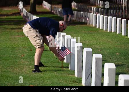 Raleigh, NC, USA, 25. Mai 2024; Eric Duke of Raleigh schließt sich freiwilligen Helfern an, die die 6.000 Grabsteine auf dem Raleigh National Cemetery vor dem Memorial Day festsetzen. Die jährliche Veranstaltung, die von der Raleigh American Legion organisiert wird, ehrt die amerikanischen Männer und Frauen, die in Friedenszeiten und Krieg im US-Militär gedient haben. Der Raleigh National Cemetery umfasst die Grabstätten von Soldaten aus dem Bürgerkrieg bis zu den Kriegen im Irak und Afghanistan. Credit D Guest Smith / Alamy Live News Stockfoto