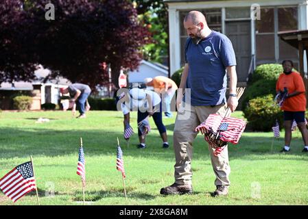 Raleigh, NC, USA, 25. Mai 2024; freiwillige legen die 6.000 Grabsteine auf dem Raleigh National Cemetery vor dem Memorial Day fest. Die jährliche Veranstaltung, die von der Raleigh American Legion organisiert wird, ehrt die amerikanischen Männer und Frauen, die in Friedenszeiten und Krieg im US-Militär gedient haben. Der Raleigh National Cemetery umfasst die Grabstätten von Soldaten aus dem Bürgerkrieg bis zu den Kriegen im Irak und Afghanistan. Credit D Guest Smith / Alamy Live News Stockfoto