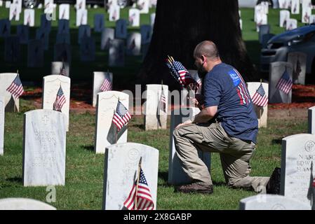 Raleigh, NC, USA, 25. Mai 2024; freiwillige legen die 6.000 Grabsteine auf dem Raleigh National Cemetery vor dem Memorial Day fest. Die jährliche Veranstaltung, die von der Raleigh American Legion organisiert wird, ehrt die amerikanischen Männer und Frauen, die in Friedenszeiten und Krieg im US-Militär gedient haben. Der Raleigh National Cemetery umfasst die Grabstätten von Soldaten aus dem Bürgerkrieg bis zu den Kriegen im Irak und Afghanistan. Credit D Guest Smith / Alamy Live News Stockfoto