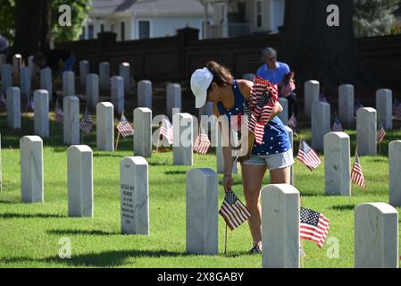 Raleigh, NC, USA, 25. Mai 2024; freiwillige legen die 6.000 Grabsteine auf dem Raleigh National Cemetery vor dem Memorial Day fest. Die jährliche Veranstaltung, die von der Raleigh American Legion organisiert wird, ehrt die amerikanischen Männer und Frauen, die in Friedenszeiten und Krieg im US-Militär gedient haben. Der Raleigh National Cemetery umfasst die Grabstätten von Soldaten aus dem Bürgerkrieg bis zu den Kriegen im Irak und Afghanistan. Credit D Guest Smith / Alamy Live News Stockfoto