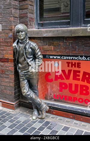 Bronzestatue von John Lennon, der sich am 20. Mai 2024 an die Wand vor der Cavern Bar in der Matthew Street, Liverpool, Merseyside, Großbritannien lehnte Stockfoto