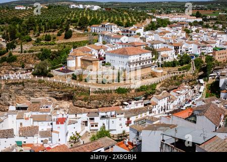 Blick auf die Skyline mit Blick auf den Rio Trejo und die Kirche Ermita de Nuestra Señora del Carmen in den einzigartigen Pueblos blanco von Setenil de las Bodegas, Spanien. Die Bewohner des kleinen Dorfes Setenil leben seit dem neolithikum in Höhlenhäusern. Stockfoto