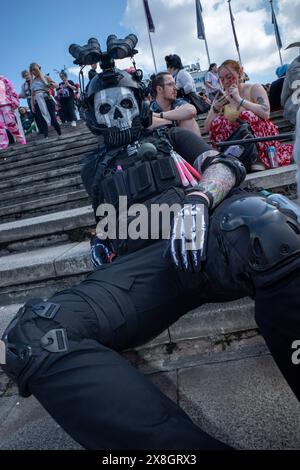 London, Großbritannien, 25. Mai 2024. Ein Besucher der Comic Con London trägt eine schwarze Polizeiuniform und eine Totenkopfmaske, während er sich auf den Stufen des Excel Centre zurücklegt. Quelle: James Willoughby/Alamy Live News Stockfoto