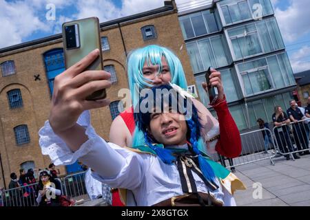 London, Großbritannien, 25. Mai 2024. Zwei Besucher am zweiten Tag der Comic Con London machen ein Selfie mit einem Mobiltelefon vor dem Veranstaltungsort. Quelle: James Willoughby/Alamy Live News Stockfoto