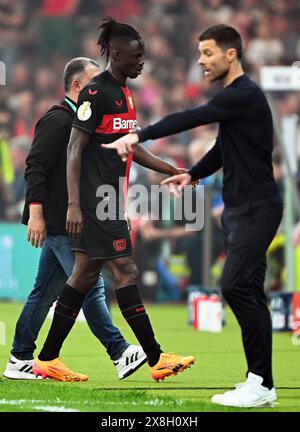 Berlin, Deutschland. Mai 2024. Fußball: DFB Cup, 1. FC Kaiserslautern - Bayer Leverkusen, Finale, Olympiastadion. Leverkusens Odilon Kossounou (M) verlässt das Feld neben Leverkusener Trainer Xabi Alonso (r), nachdem er abgeschickt wurde. WICHTIGER HINWEIS: Gemäß den Vorschriften der DFL Deutscher Fußball-Liga und des DFB Deutscher Fußball-Bundes ist es verboten, im Stadion und/oder im Spiel aufgenommene Fotografien in Form von sequenziellen Bildern und/oder videoähnlichen Fotoserien zu verwenden oder zu verwenden. Quelle: Federico Gambarini/dpa/Alamy Live News Stockfoto