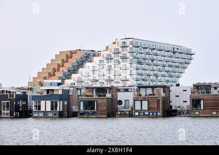 Niederlande, Amsterdam - 6. April 2024: Sluishuis modernes Wohngebäude im Stadtteil Ijburg, entworfen von Bjarke Ingels Group, GROSS Stockfoto