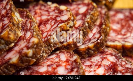 In Scheiben Geschnittene Delikatessen. Salamischeiben mit komplizierten Fettmustern, perfekt für die Lebensmittelindustrie und Gourmet-Grafiken. Stockfoto