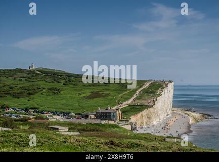 Birling Gap, Eastbourne, East Sussex, Großbritannien. Mai 2024. Besucher drängen sich zu der herrlichen Stätte auf dem South Downs Way, viele treffen sich auf den Klippen oberhalb von Birling Gap, einige scheinen sich der Fragilität und Unterschneidung der Kreide nicht bewusst zu sein. Warnschilder sind sehr spärlich und wurden seit einigen Jahren nicht mehr aktualisiert. Ein Sicherheitsseil vom Beachy Head zum Leuchtturm von Belle Tout, das effektiv zu sein scheint, geht nicht weiter bis nach Birling Gap. Quelle: David Burr/Alamy Live News Stockfoto