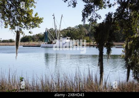 Ein Krabbenschlepper legte am Jeremy Creek an und umrahmt von spanischem Moos in dem winzigen Küstendorf McClellanville, South Carolina. Stockfoto