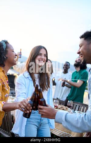 Junge multirassische Jugendliche tanzen zusammen auf einer Dachparty draußen. Verschiedene fröhliche Freunde Stockfoto