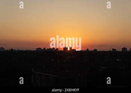 Orangefarbener Sonnenuntergang - Silhouette der Skyline der Stadt - dunkle Konturen der Gebäude im Kontrast zum verblassten Licht. Aufgenommen in Toronto, Kanada. Stockfoto