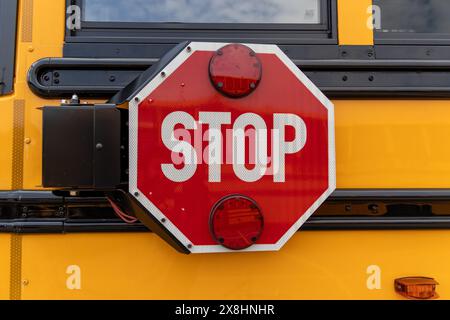 Nahaufnahme des rot-weißen STOPPSCHILDES - gelber Schulbus - klarer blauer Himmel. Aufgenommen in Toronto, Kanada. Stockfoto