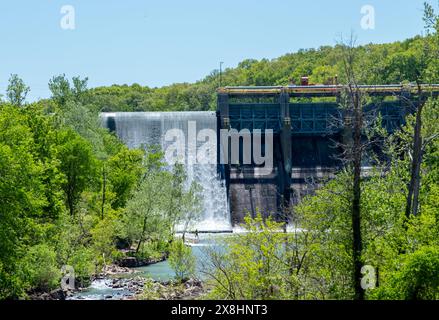 An einem warmen, sonnigen Sommertag mit hübscher grüner Umgebung kaskadiert das Wasser sanft und anmutig über einen Damm in Oklahoma. Stockfoto