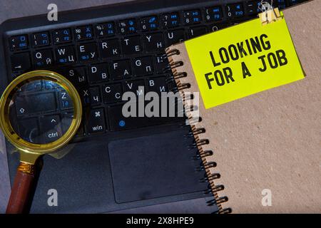 Visitenkarte aus Kraftpapier mit auffälliger Suche nach einem Text für einen Teilzeitjob auf einem gut beleuchteten Schreibtisch. Mit Taschenrechner, Stift und leuchtend grüner Pflanze. Ideal für Stockfoto