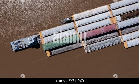 Ein Schleppboot, bekannt als Schieber, schiebt Binnenschiffe voller Fracht auf den Mississippi River in der Nähe der Innenstadt von Baton Rouge, Louisiana, USA. Stockfoto