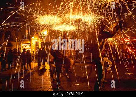 Barcelona, Spanien. Mai 2024. Feuerläufer tanzen zu traditionellen Trommeln unter Feuerwerk, um den 30. Jahrestag der „Diables de les Corts“ zu feiern Stockfoto