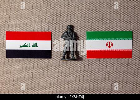 Eine Soldatenfigur auf dem Hintergrund der Flaggen des Iran und des Irak Stockfoto