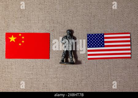 Eine Soldatenfigur auf dem Hintergrund der Fahnen der USA und Chinas Stockfoto