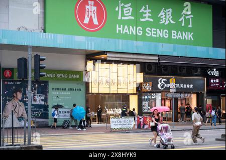 Hongkong, China. Mai 2024. Fußgänger werden über die Straße vor der Hang Seng Bank Filiale in Hongkong gesehen. (Foto: Sebastian ng/SOPA Images/SIPA USA) Credit: SIPA USA/Alamy Live News Stockfoto