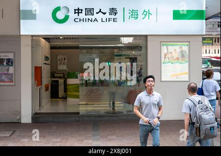 Hongkong, China. Mai 2024. Fußgänger überqueren die Straße vor der chinesischen Versicherung China Life in Hongkong. (Foto: Sebastian ng/SOPA Images/SIPA USA) Credit: SIPA USA/Alamy Live News Stockfoto