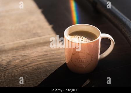 Lebe jeden Moment. Bildunterschrift auf einem Becher mit dem Regenbogen Stockfoto