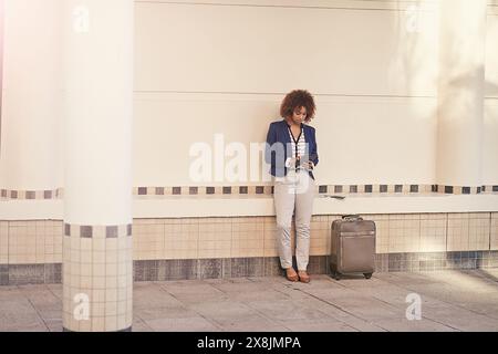 Geschäftsfrau, Tablet und Gepäck am Bahnhof mit Lesen, App und Reiseplan. Person, digitaler Touchscreen und Koffer an der Wand Stockfoto