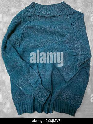 Handgefertigte Strickwaren. Strickstoff aus dunklen Garnen. Pullover für Frauen. Kopierbereich Stockfoto