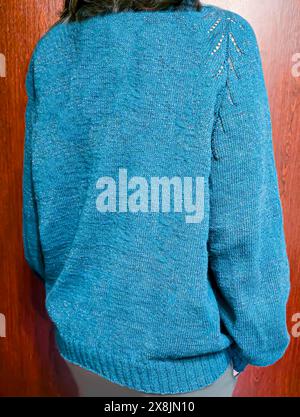 Handgefertigte Strickwaren. Strickstoff aus dunklen Garnen. Pullover für Frauen. Kopierbereich Stockfoto