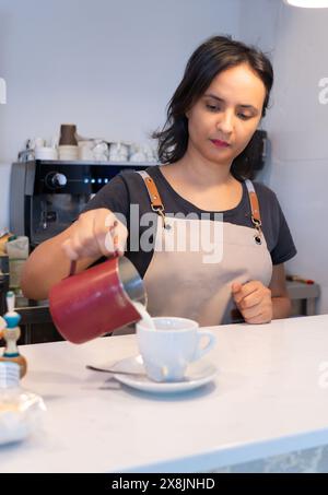 Die marokkanische Kellnerin serviert einen Latte in einem Café Stockfoto