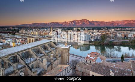 Tortosa bei Sonnenaufgang, von der Burg Suda aus gesehen. Im Vordergrund die Kathedrale und der Fluss Ebro. Im Hintergrund die Häfen (Tarragona, Spanien) Stockfoto