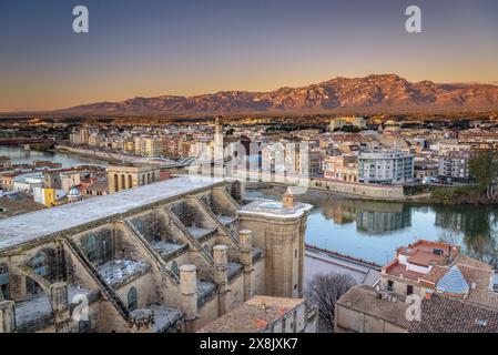 Tortosa bei Sonnenaufgang, von der Burg Suda aus gesehen. Im Vordergrund die Kathedrale und der Fluss Ebro. Im Hintergrund die Häfen (Tarragona, Spanien) Stockfoto